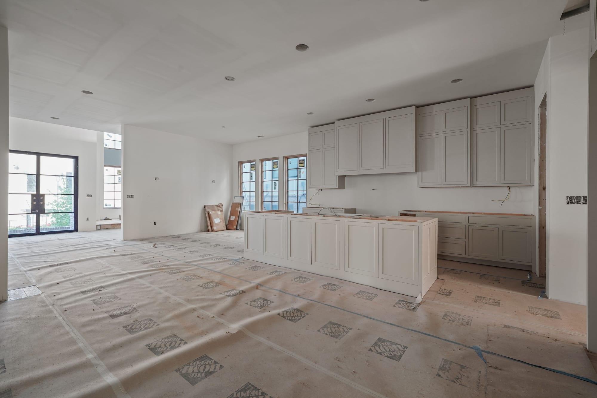 Kitchen island and cabinets installed before counters with floors protected
