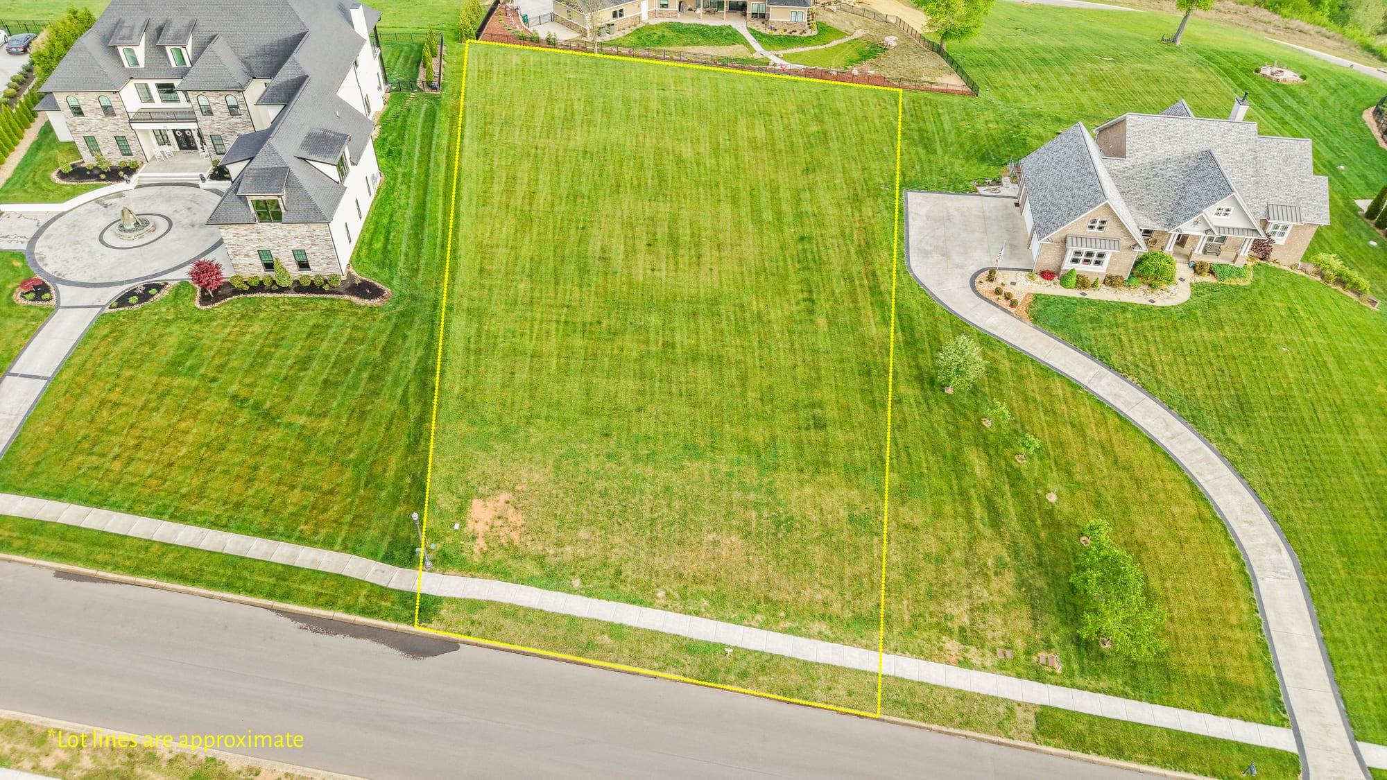 Drone aerial of the vacant lot with marketing lot lines drawn over the grass