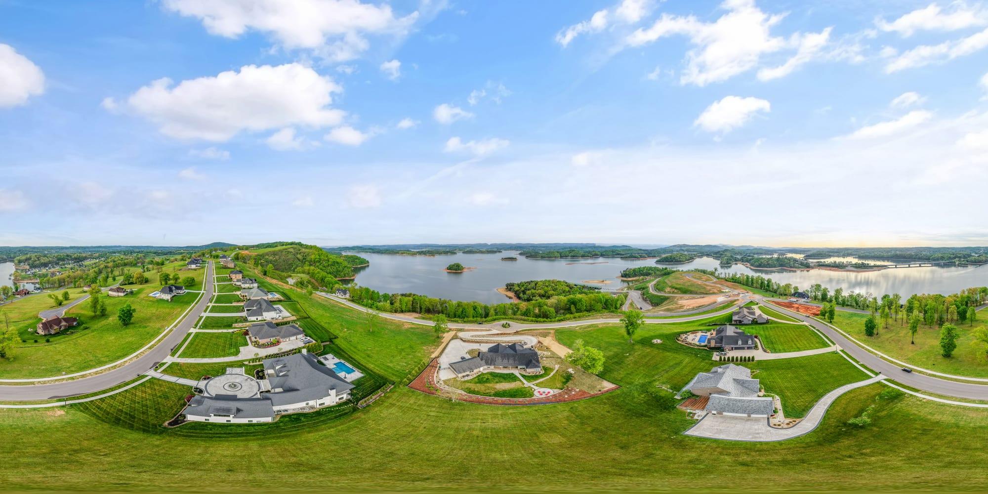 Sweeping drone panorama of the lakefront peninsula community around the lot