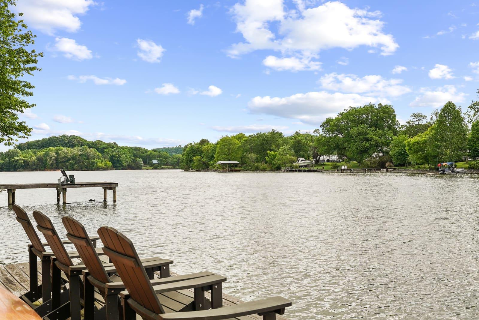 Adirondack chairs on a private dock at the lake — a guest-facing amenity frame