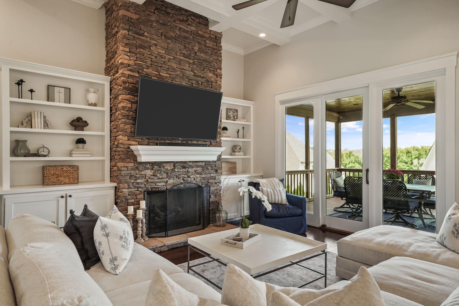Living room with a stone fireplace and built-in shelving