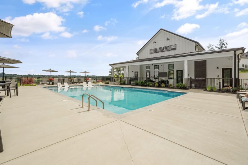 Pool deck with the white farmhouse-style clubhouse behind