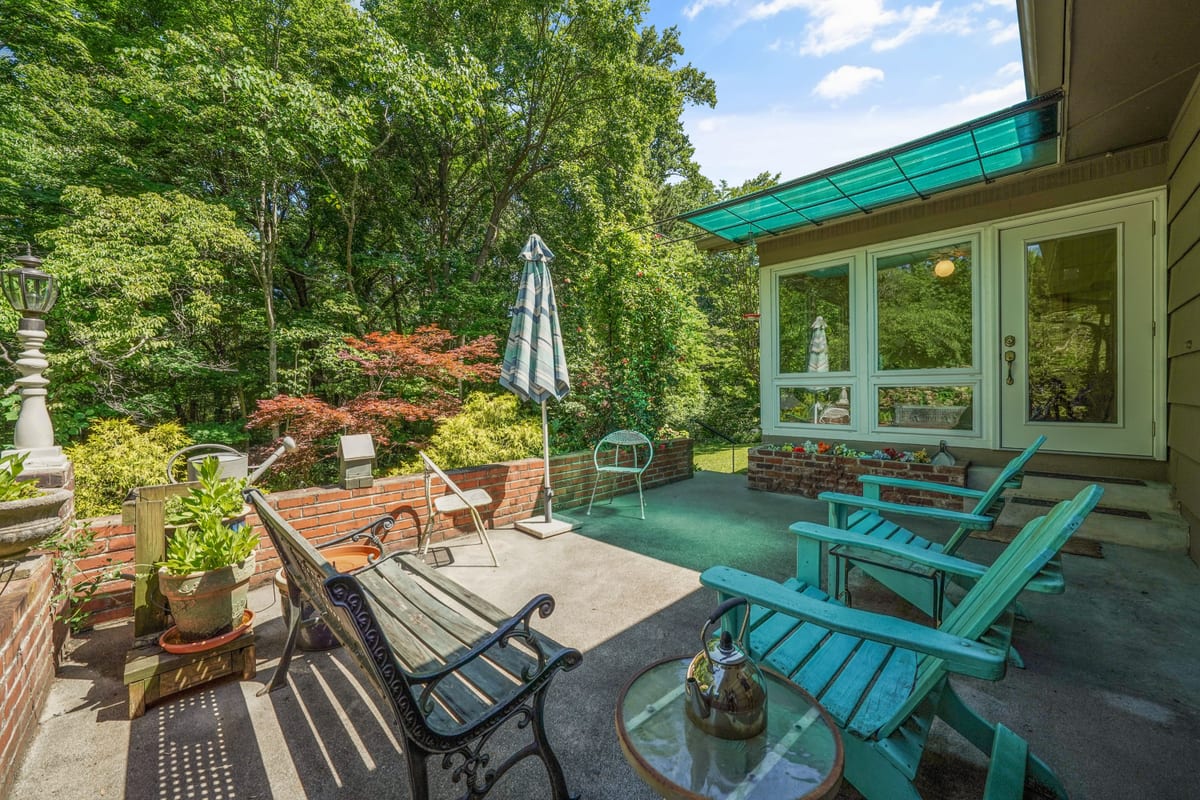Flagstone patio with teal adirondack chairs at the garden edge