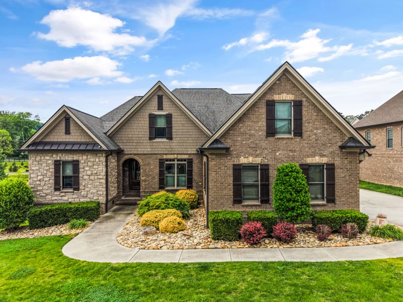 Symmetrical brick and stone craftsman elevation under a deep blue sky
