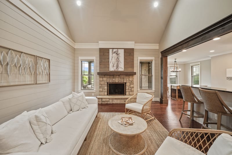 Living room with stone fireplace, shiplap, and styled white seating