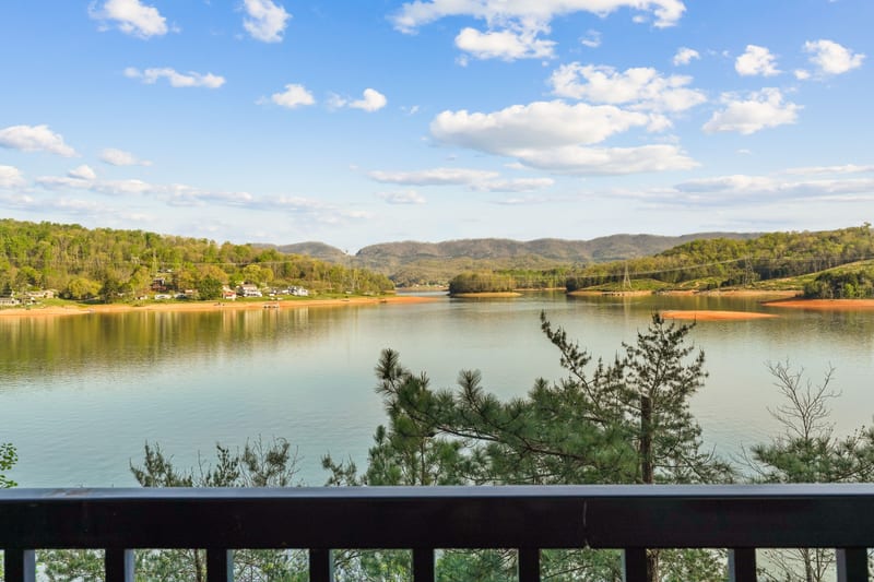 Balcony view across a calm lake in warm late-afternoon light