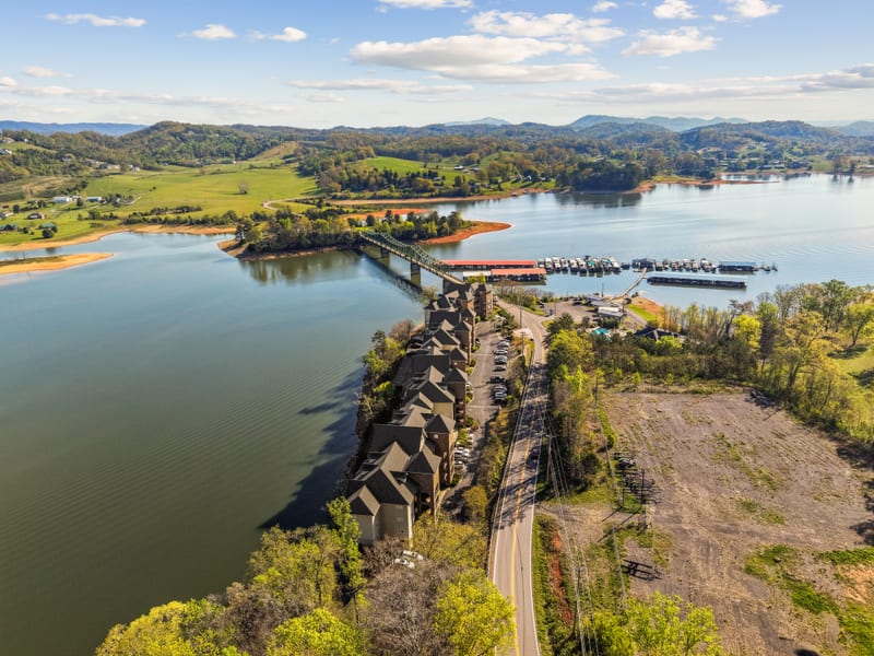 Drone aerial of a steel bridge crossing to a marina along a mountain lake