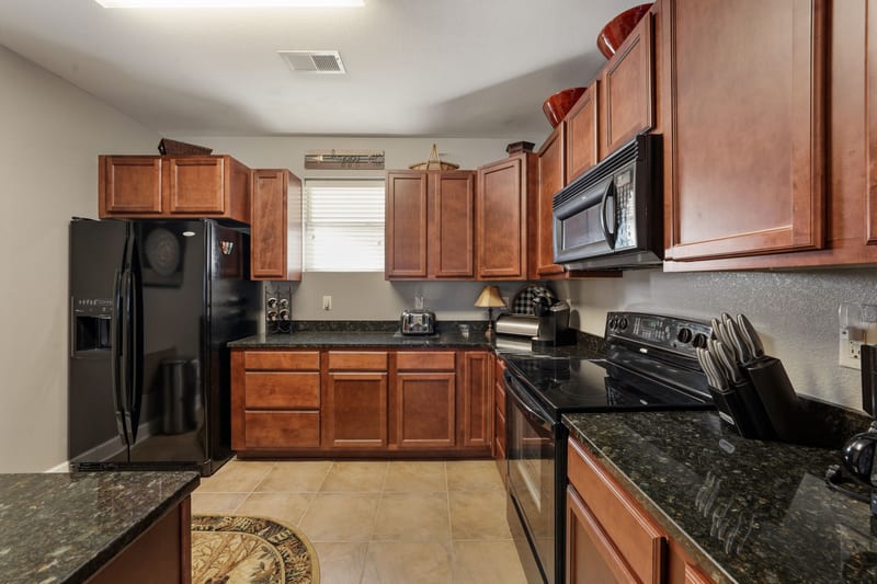Condo kitchen with cherry cabinets and granite counters