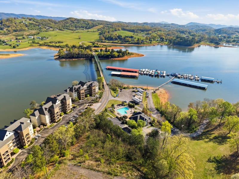 Drone aerial of a condo peninsula with marina, pool, and open lake
