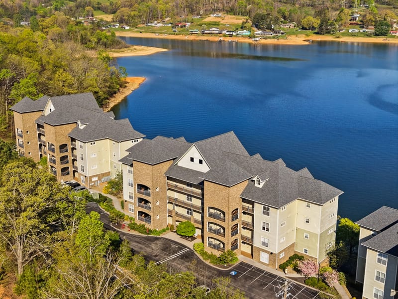 Drone view of lakefront residences stepping along a blue-water shoreline