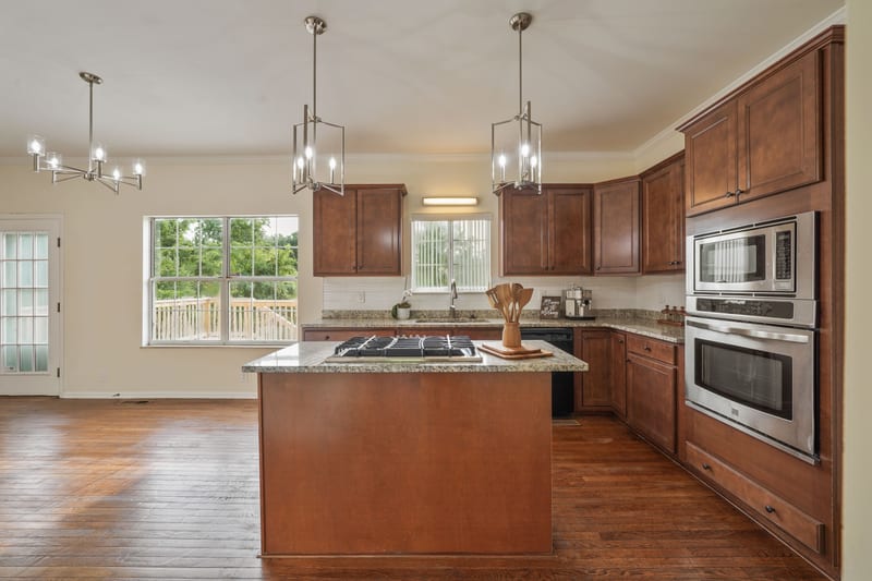 Kitchen island with double ovens and lantern pendants