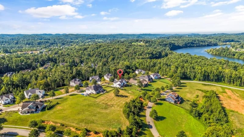 Drone aerial of the hillside community with a lake in the distance