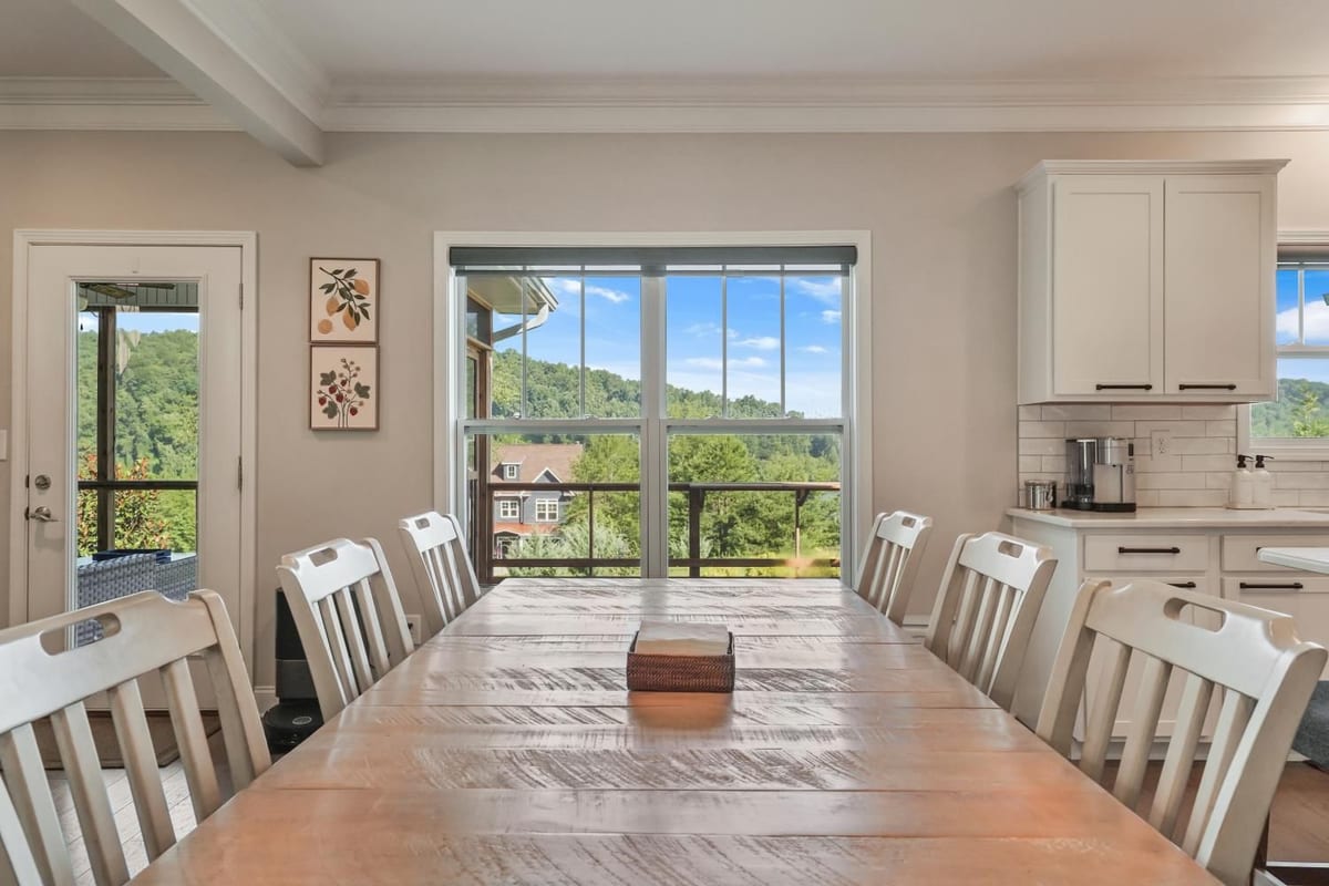 Farmhouse dining table set against a large window with a long valley view