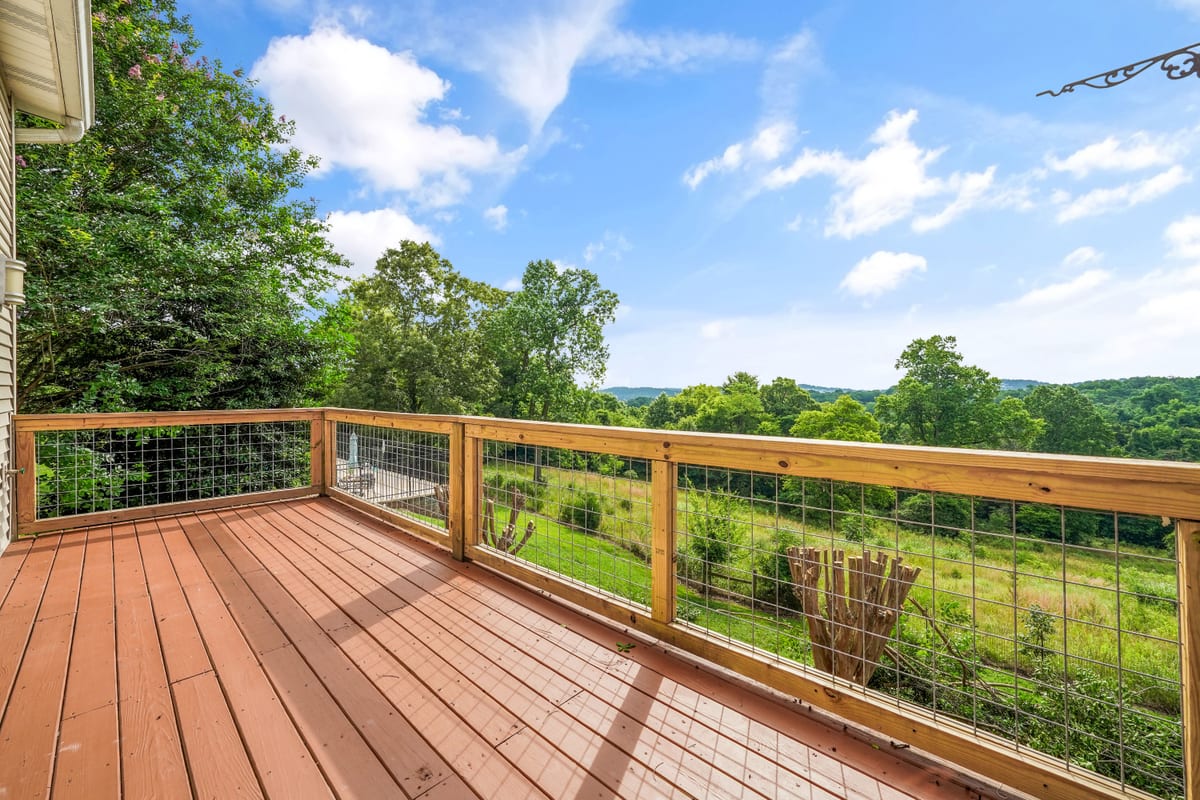 Deck rail overlooking the wooded ridgeline (detail crop)