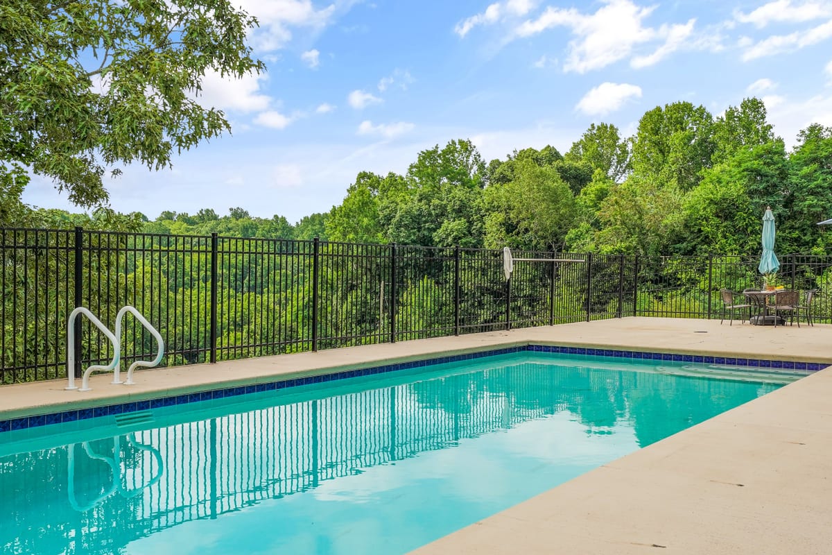 Ground-level view of the pool behind a black iron fence