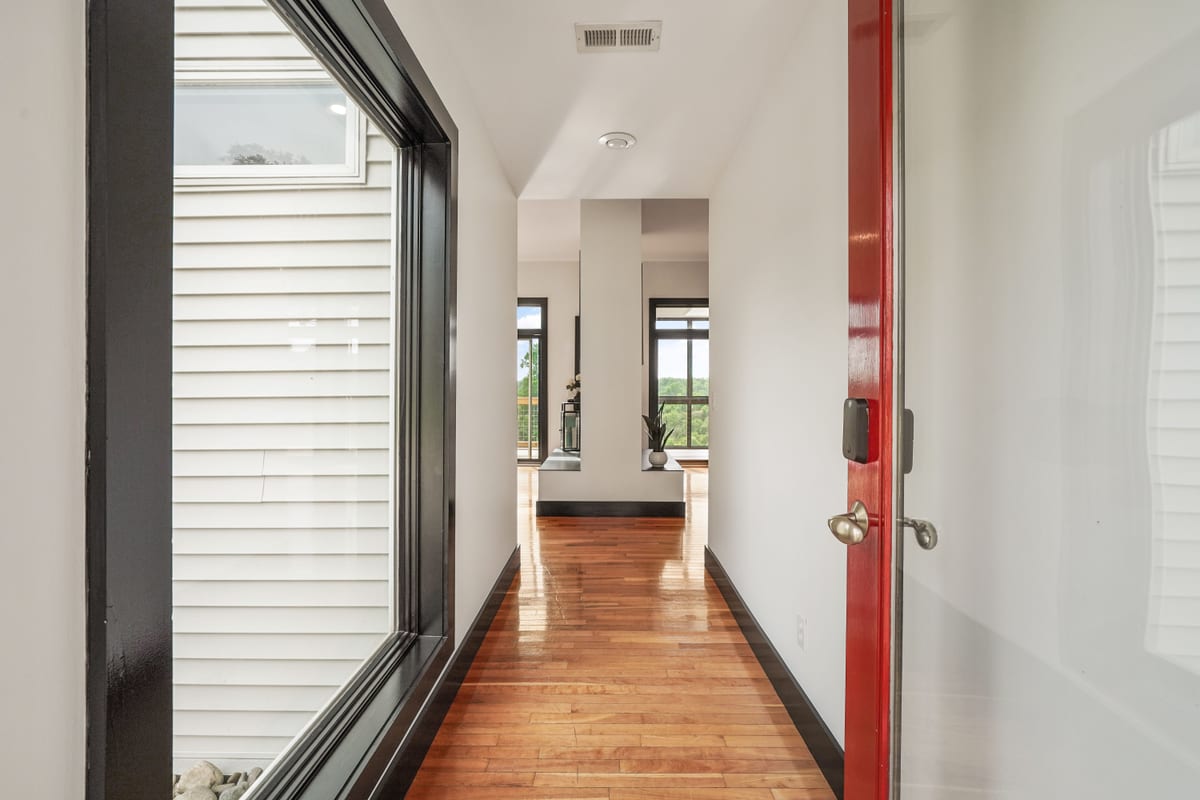 Red front door opening into a gallery hall