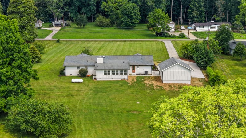 Overhead drone view of the ranch, outbuilding, and manicured acreage