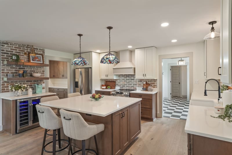 Kitchen island with brick backsplash and stained-glass pendants